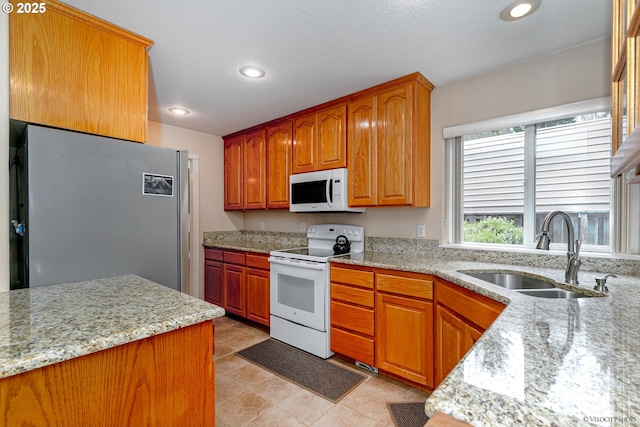 24788 E Mckenzie Valley Ct, Welches, OR 97067 - kitchen with white appliances, light stone countertops, recessed lighting, light tile patterned flooring, and a sink