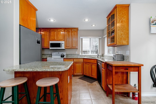24788 E Mckenzie Valley Ct, Welches, OR 97067 - kitchen with a breakfast bar, recessed lighting, glass insert cabinets, appliances with stainless steel finishes, and a sink
