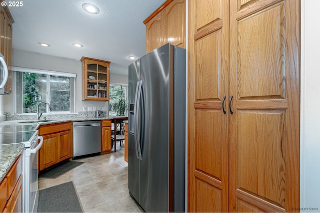 24788 E Mckenzie Valley Ct, Welches, OR 97067 - kitchen featuring a healthy amount of sunlight, glass insert cabinets, light stone counters, and appliances with stainless steel finishes