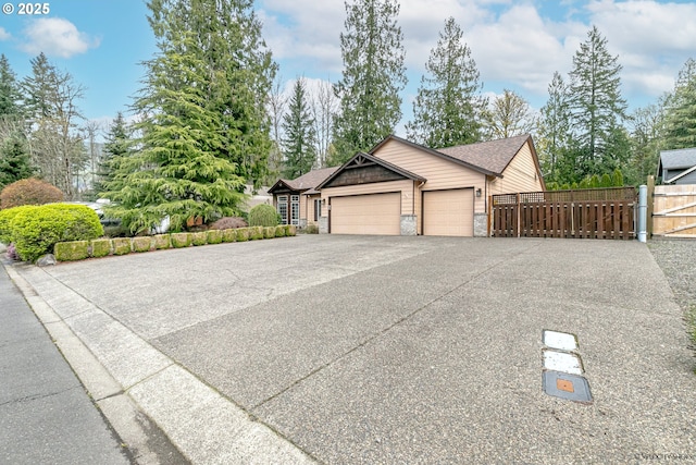 24788 E Mckenzie Valley Ct, Welches, OR 97067 - view of front facade featuring driveway, a garage, stone siding, and fence