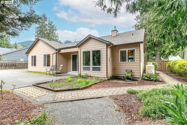 24788 E Mckenzie Valley Ct, Welches, OR 97067 - view of front of home with fence, a patio, driveway, and a chimney