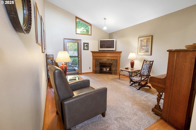 carpeted living room featuring a fireplace and high vaulted ceiling