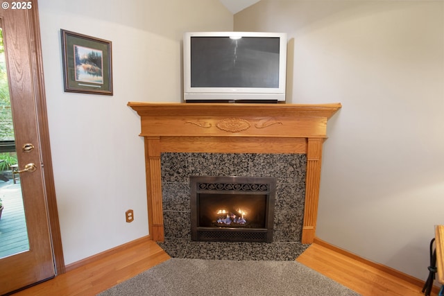 interior details featuring hardwood / wood-style floors and a tile fireplace