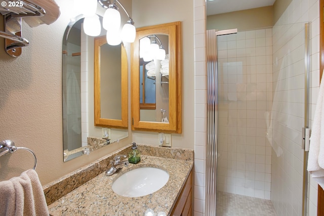 bathroom featuring vanity and a shower with shower door