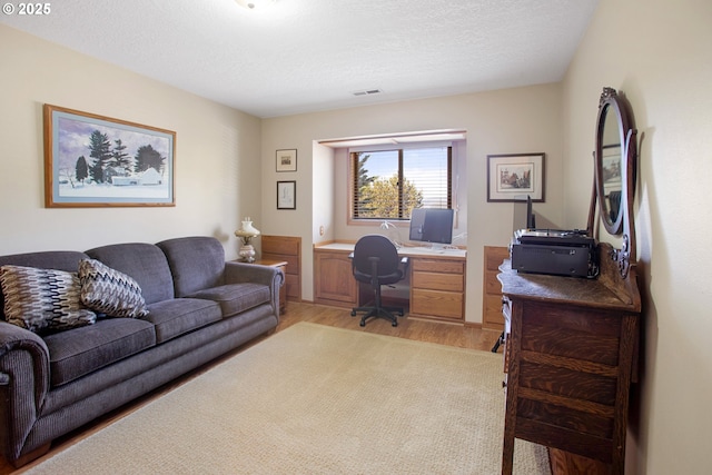 office featuring a textured ceiling and light hardwood / wood-style floors