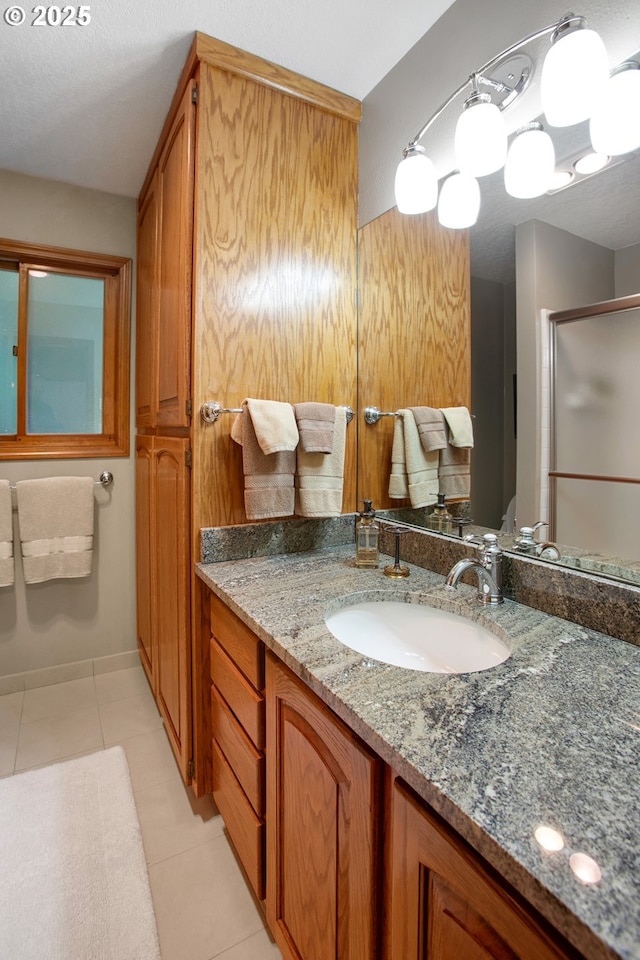 bathroom featuring vanity, tile patterned floors, and walk in shower