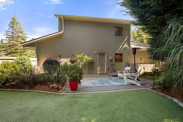 back of house with a patio and a lawn