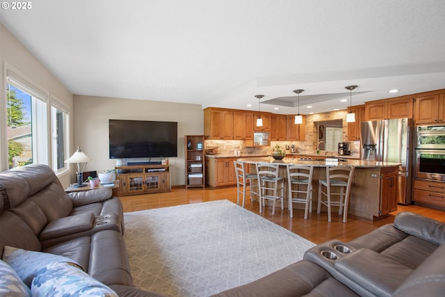 living room with a raised ceiling and light wood-type flooring