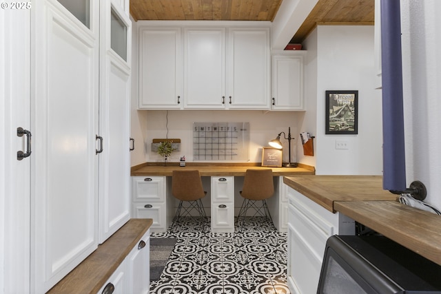 office space featuring tile patterned flooring, wood ceiling, and built in study area