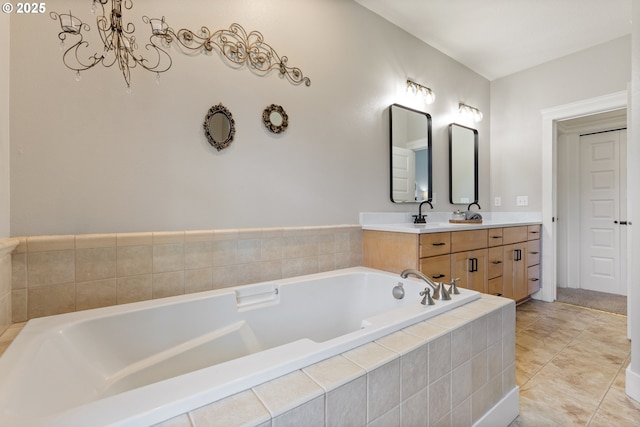 bathroom featuring double vanity, tile patterned floors, a garden tub, and a notable chandelier