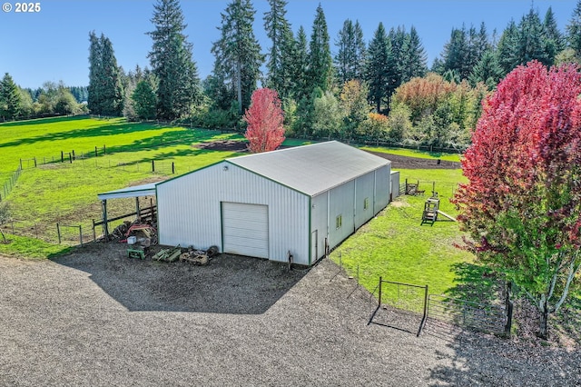 view of outbuilding with fence, an outbuilding, and driveway