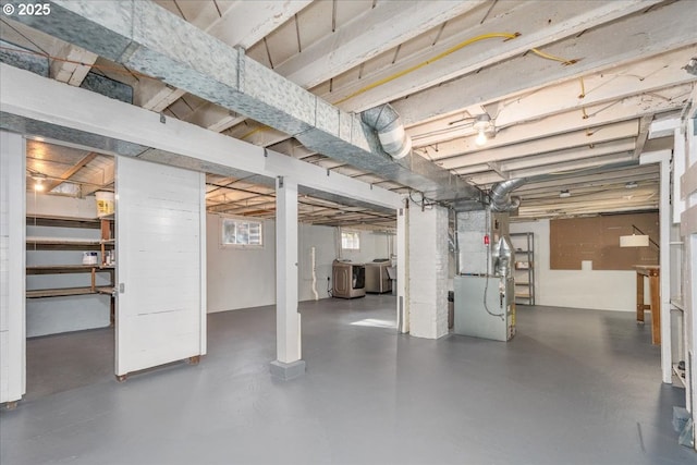 basement featuring heating unit and washing machine and dryer