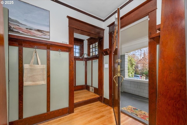 interior space with crown molding and light hardwood / wood-style floors