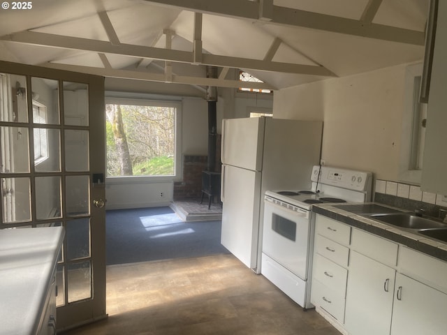 kitchen with dark countertops, a wood stove, vaulted ceiling with beams, and white electric range oven