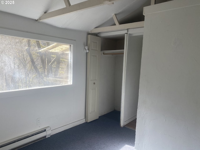 unfurnished bedroom with carpet floors, a baseboard radiator, vaulted ceiling, and a closet