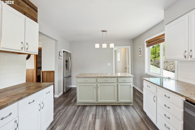 kitchen featuring backsplash, appliances with stainless steel finishes, a center island, white cabinetry, and dark wood-type flooring