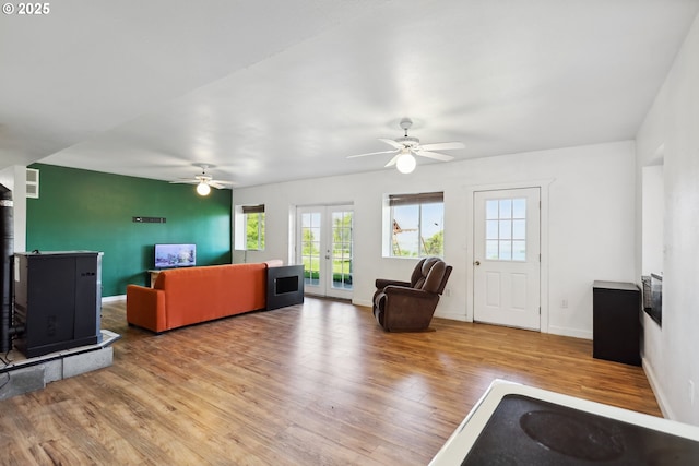 living room featuring a healthy amount of sunlight, a ceiling fan, french doors, and wood finished floors