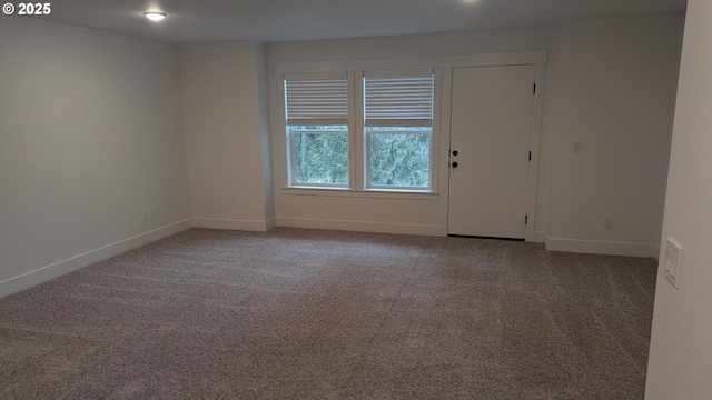 empty room featuring carpet and baseboards