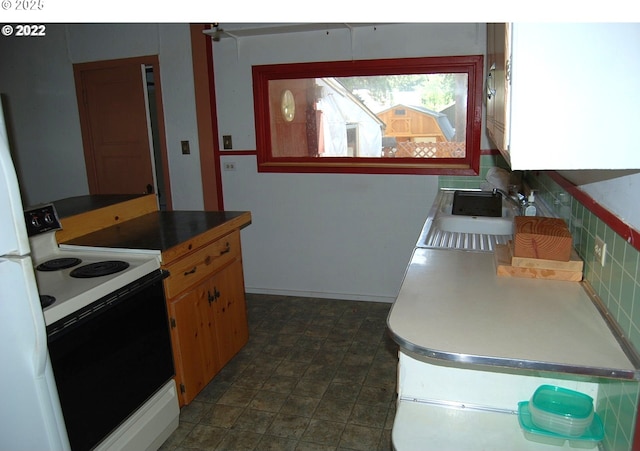 kitchen featuring electric range, a sink, and decorative backsplash