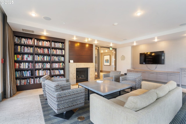 living area featuring a fireplace, visible vents, and built in features