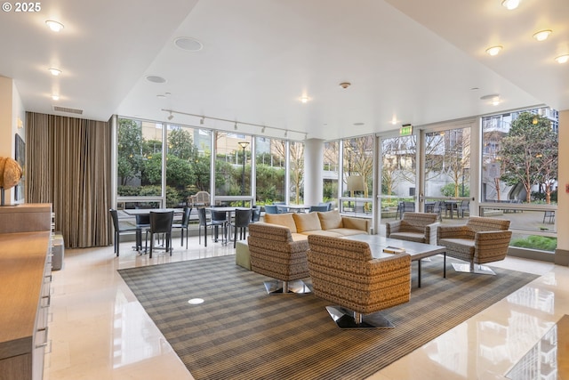 sunroom with a wall of windows, visible vents, and tile patterned floors