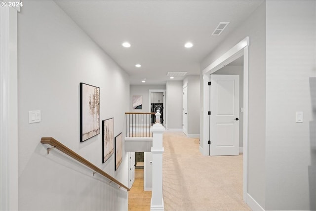 hallway featuring light colored carpet