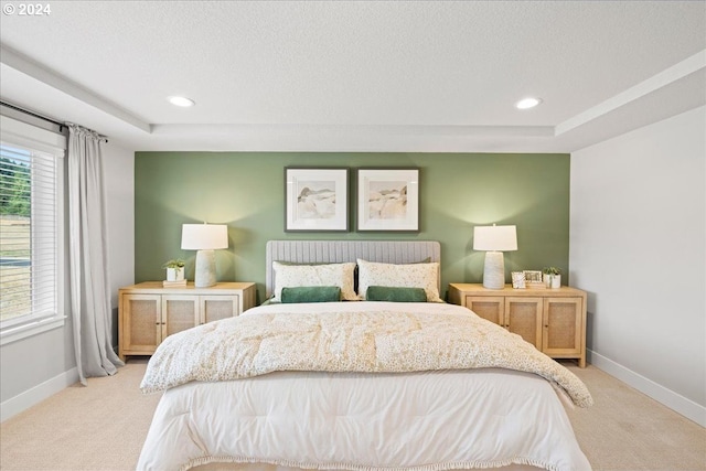 carpeted bedroom featuring a tray ceiling