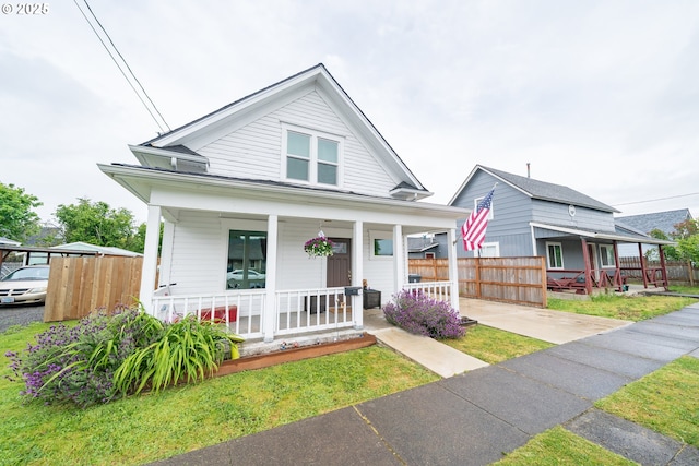 view of front of home with covered porch and fence