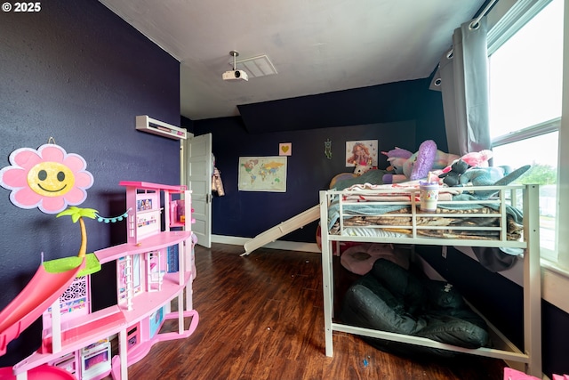 bedroom featuring wood finished floors, multiple windows, and baseboards
