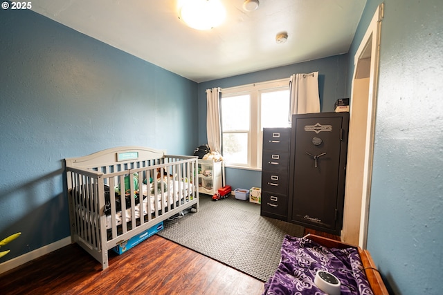 bedroom featuring wood finished floors and baseboards