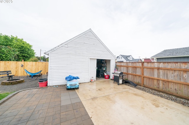 view of patio / terrace featuring a detached garage, fence, and area for grilling
