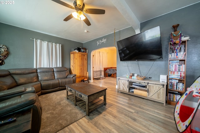 living room with light wood-style flooring, a ceiling fan, and beam ceiling