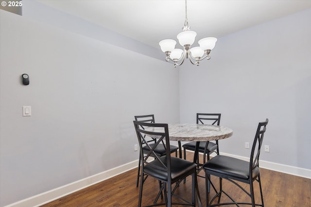 dining space featuring dark hardwood / wood-style floors and a chandelier