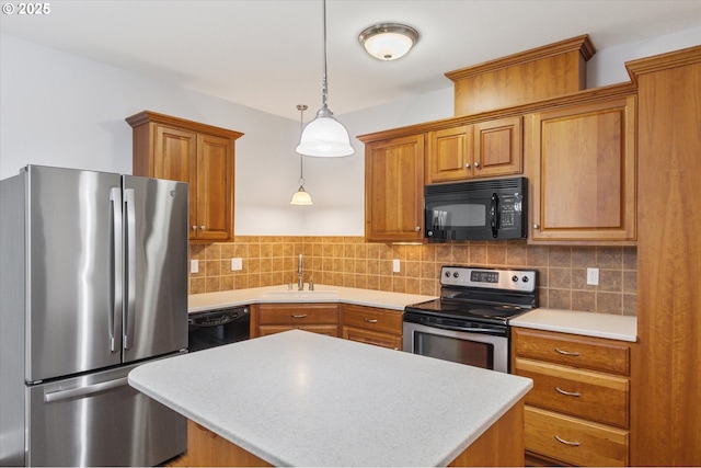 kitchen with pendant lighting, sink, decorative backsplash, and black appliances