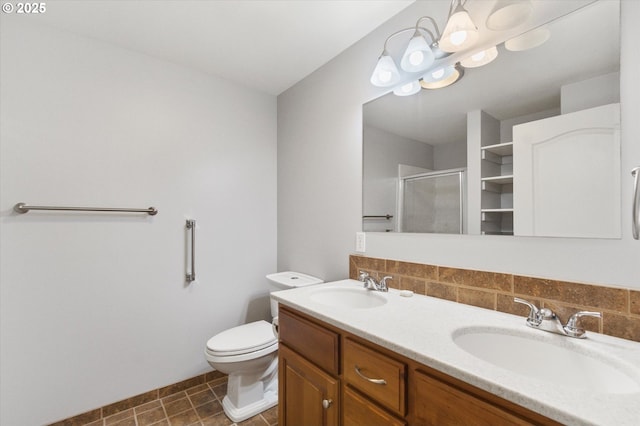 bathroom with vanity, toilet, and a shower with door