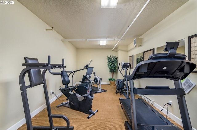 workout room featuring carpet flooring, a textured ceiling, and an AC wall unit