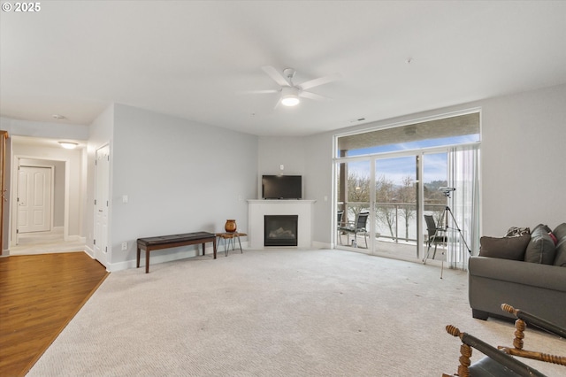 living room with floor to ceiling windows, ceiling fan, and carpet