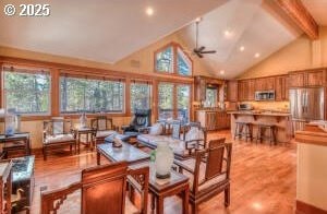 interior space featuring high vaulted ceiling, light wood-style flooring, beam ceiling, and a ceiling fan