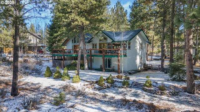 rear view of property featuring a wooden deck and a patio