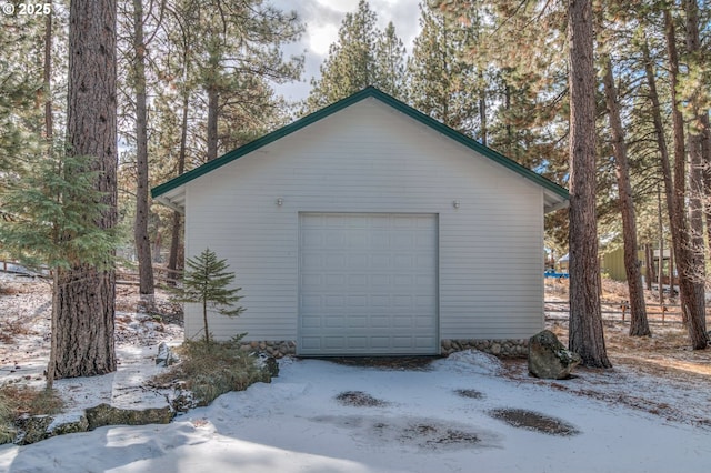 snow covered garage with a garage