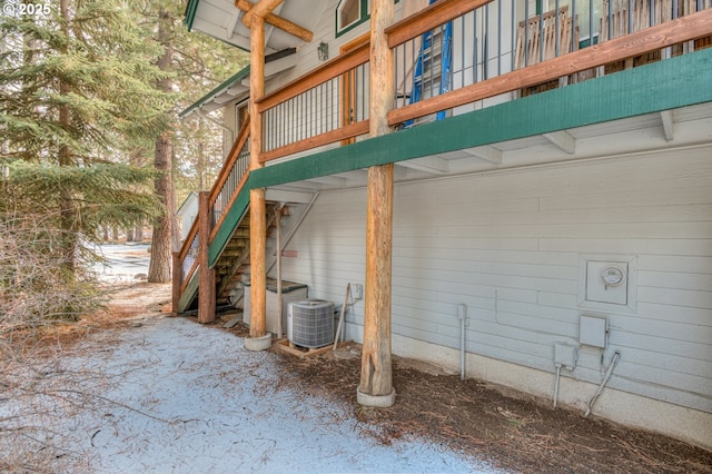 view of side of home with stairway and cooling unit