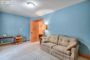 carpeted living area featuring baseboards