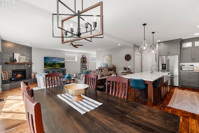 6244 SE Jess Ct, Hillsboro, OR 97123 - dining space featuring a notable chandelier, recessed lighting, a tile fireplace, and wood finished floors