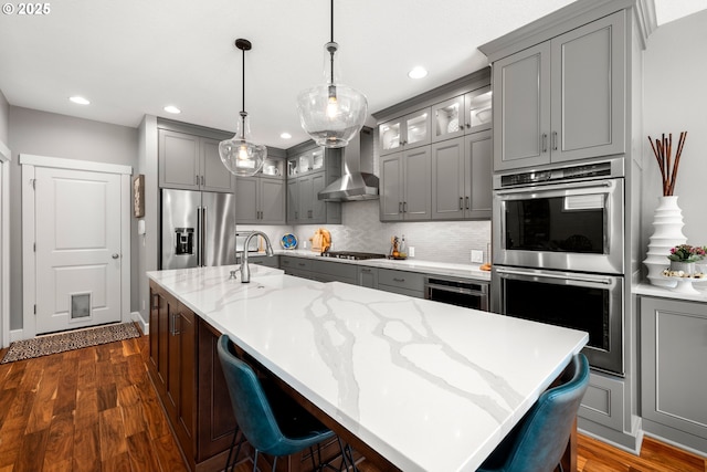 6244 SE Jess Ct, Hillsboro, OR 97123 - kitchen with wall chimney range hood, backsplash, gray cabinetry, a sink, and stainless steel appliances