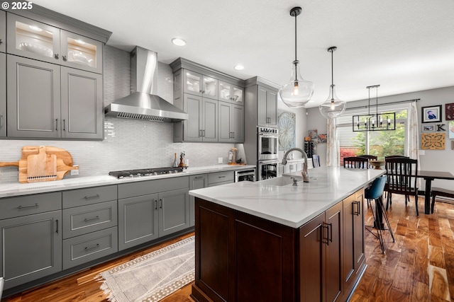 6244 SE Jess Ct, Hillsboro, OR 97123 - kitchen with wall chimney range hood, appliances with stainless steel finishes, a sink, dark wood finished floors, and gray cabinetry