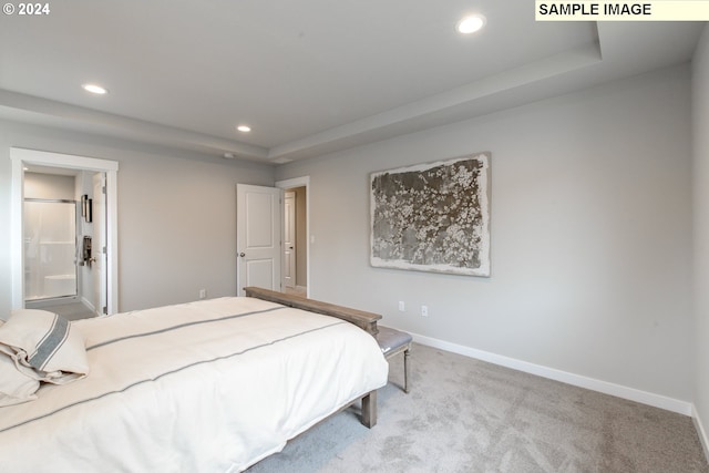 bedroom featuring baseboards, carpet flooring, recessed lighting, ensuite bath, and a raised ceiling