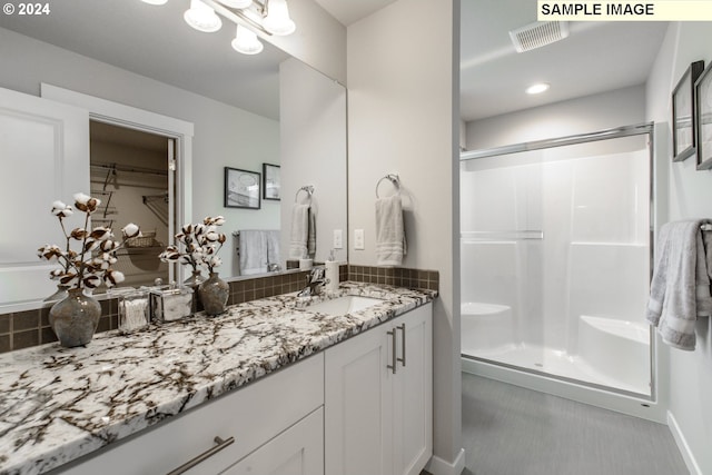 full bath with visible vents, a stall shower, and vanity