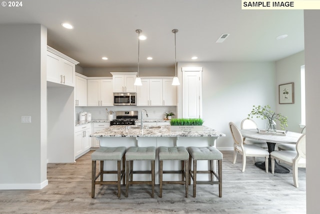 kitchen with a sink, visible vents, appliances with stainless steel finishes, and white cabinets