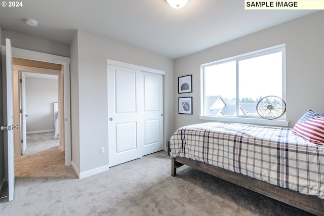 carpeted bedroom featuring a closet and baseboards