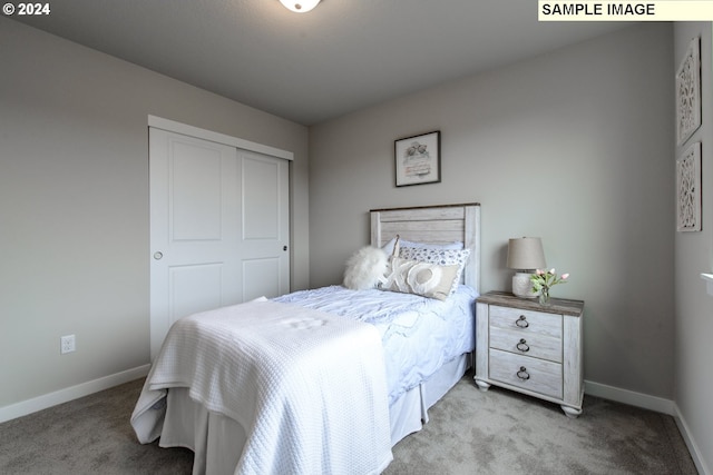 bedroom with light colored carpet, baseboards, and a closet